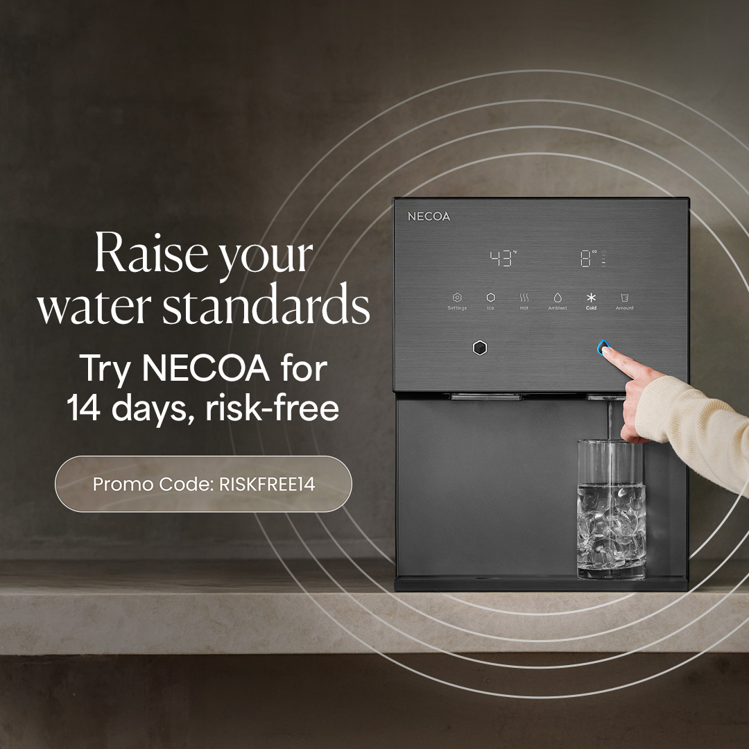 A sleek, dark grey NECOA countertop water dispenser being used to fill a glass of ice. On the left, promotional text reads, 'Raise your water standards. Try NECOA for 14 days, risk-free' with a button containing the promo code 'RISKFREE14'.