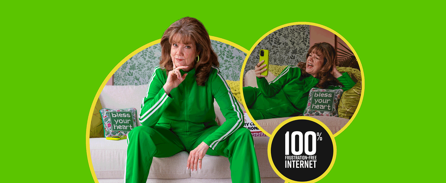 An older woman in a vibrant green tracksuit is shown in two poses on a white couch. In the left image, she is sitting upright, looking at the camera with her hand on her chin. In the right image, she is lying on the couch, holding a yellow smartphone and laughing while taking a selfie. A pillow with the text "bless your heart" is visible in both images. A circular graphic in the lower right corner displays "100% FRUSTRATION-FREE INTERNET". The scene is set against a bright lime green background with decorative wallpaper visible behind the couch.